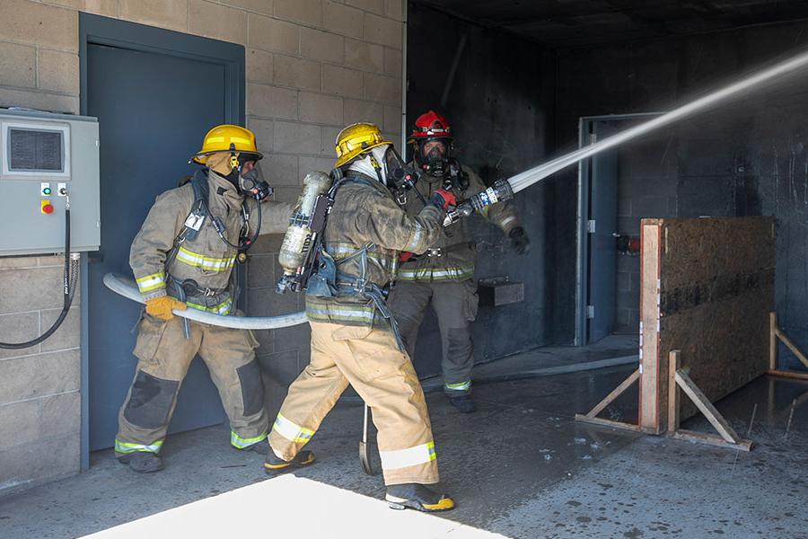 Students putting out a fire in the Fire Science Degree Program at San Juan College