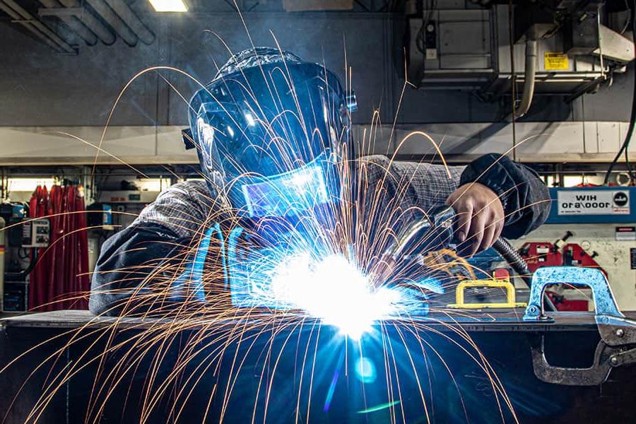 Welding student practices pipe welding.